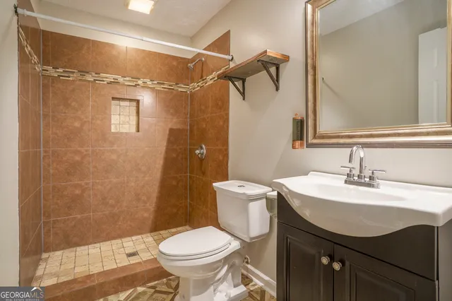 a bathroom with a sink toilet a mirror and shower