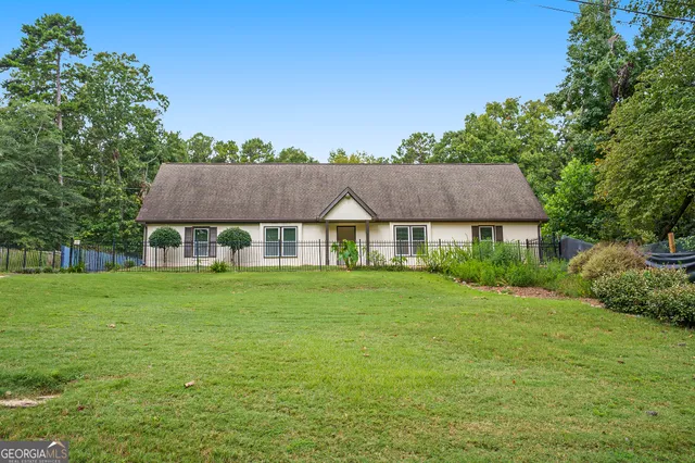 a view of a big house with a big yard and large trees