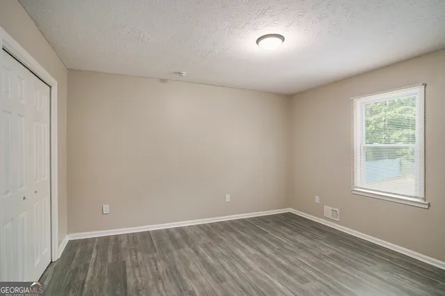 a view of a house with a backyard and a tree