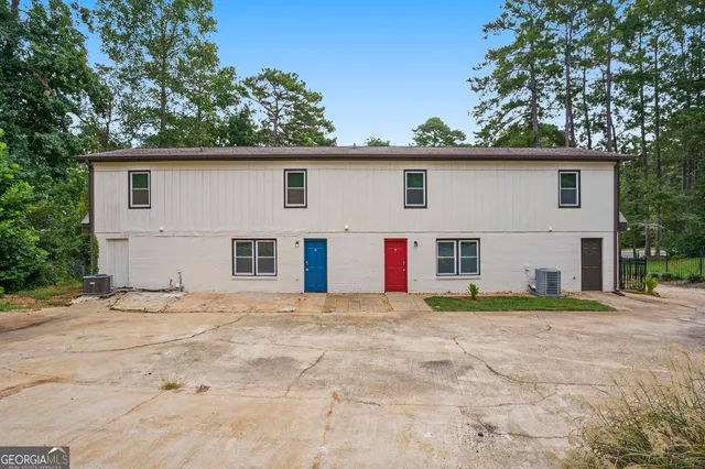 a white house that has a tree in front of it