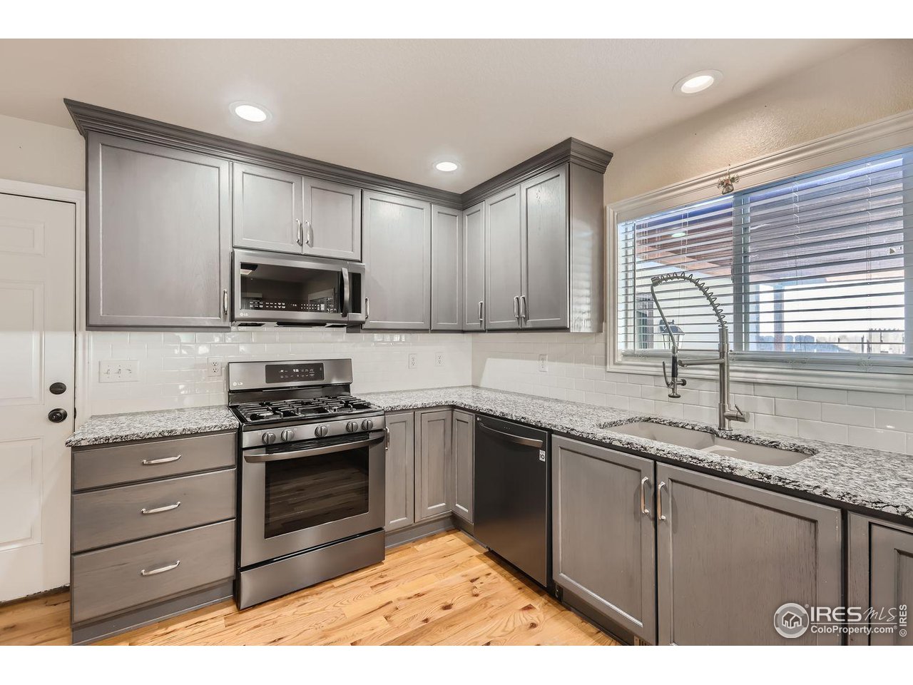 135 Falcon Circle Mead, CO 80542 - Photo 11 of 27 a kitchen with kitchen island granite countertop a sink cabinets and stainless steel appliances