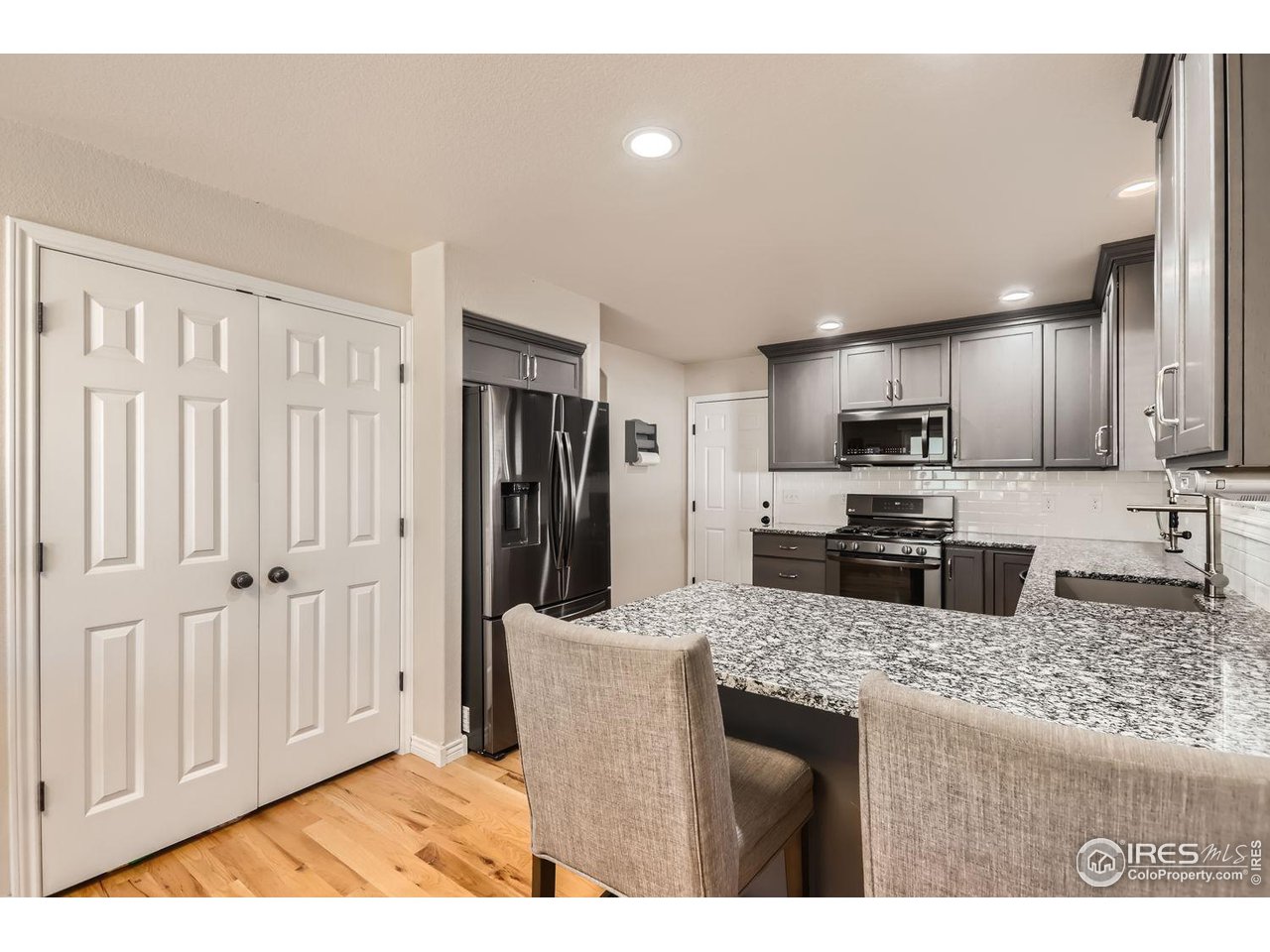 135 Falcon Circle Mead, CO 80542 - Photo 13 of 27 a kitchen with stainless steel appliances granite countertop a refrigerator a sink a stove with wooden cabinets