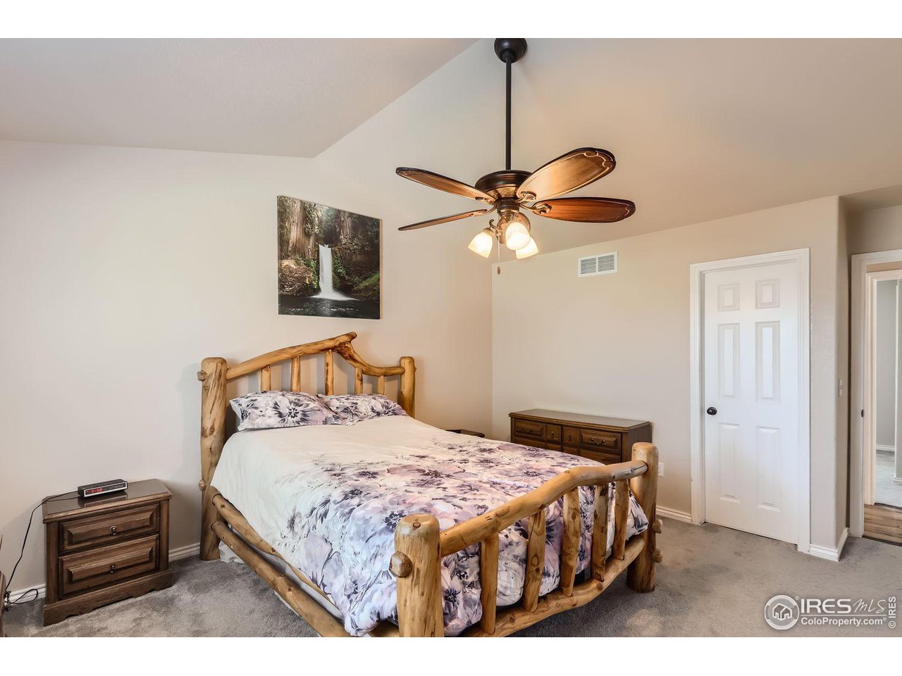 135 Falcon Circle Mead, CO 80542 - Photo 15 of 27 a bedroom with a bed and a chandelier