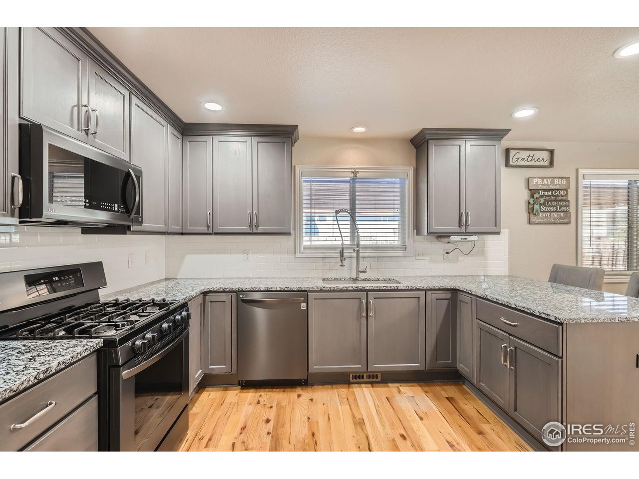 135 Falcon Circle Mead, CO 80542 - Photo 9 of 27 a kitchen with stainless steel appliances granite countertop a sink stove microwave and cabinets
