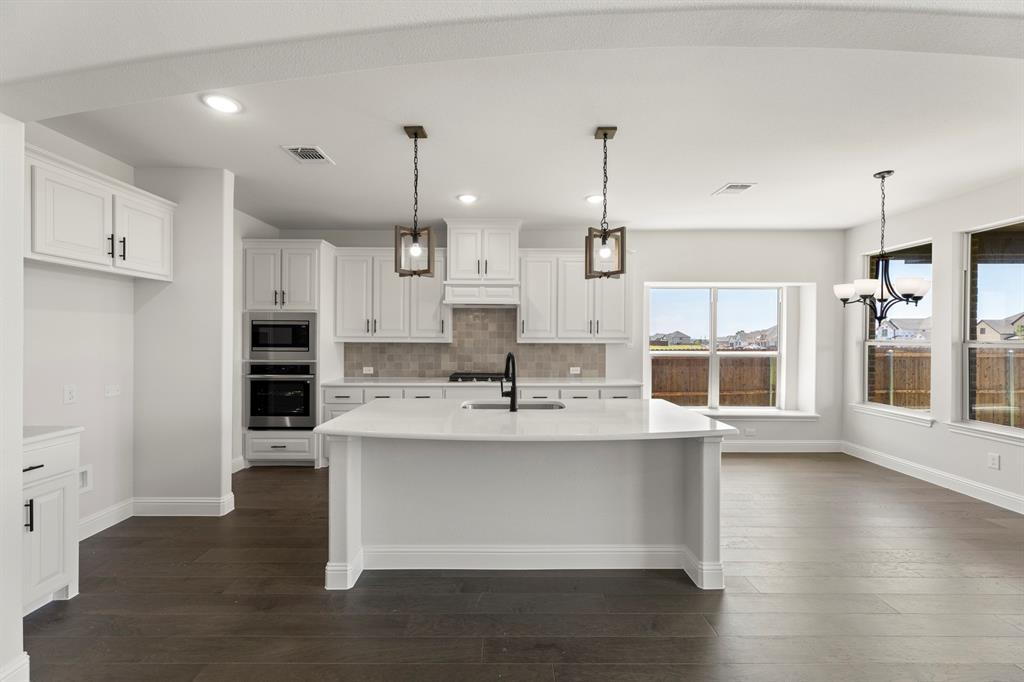 505 Alto Avenue Forney, TX 75126 - Photo 4 of 32 a large kitchen with stainless steel appliances kitchen island granite countertop a large stove a refrigerator and a wooden cabinets