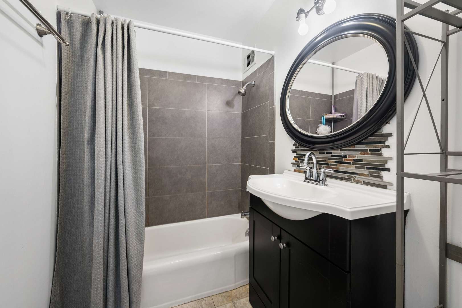 6157 North Sheridan Road, Unit 6K Chicago, IL 60660 - Photo 13 of 18 a bathroom with a sink a bathtub and a mirror