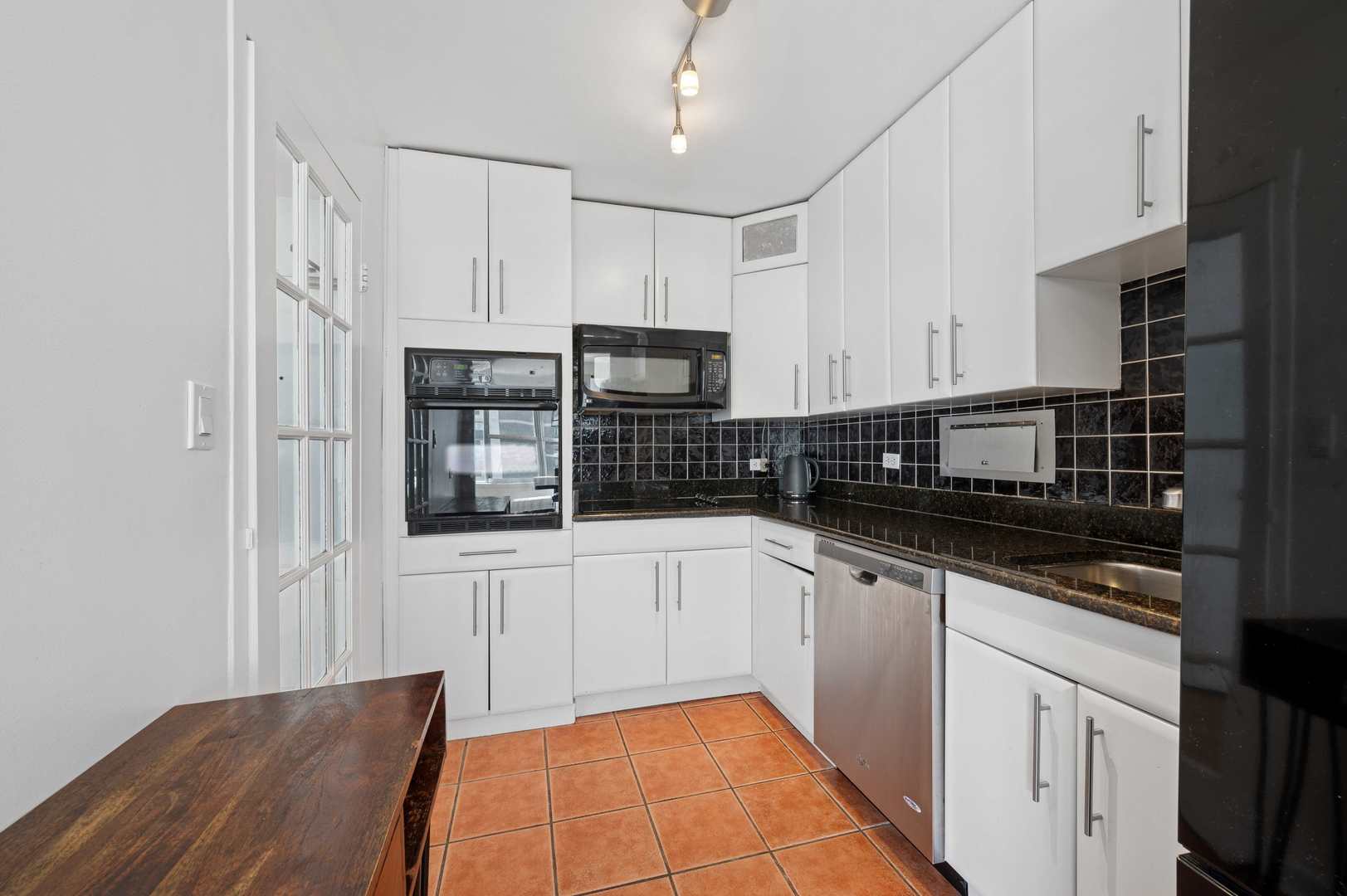 6157 North Sheridan Road, Unit 6K Chicago, IL 60660 - Photo 8 of 18 a kitchen with stainless steel appliances granite countertop a sink and cabinets