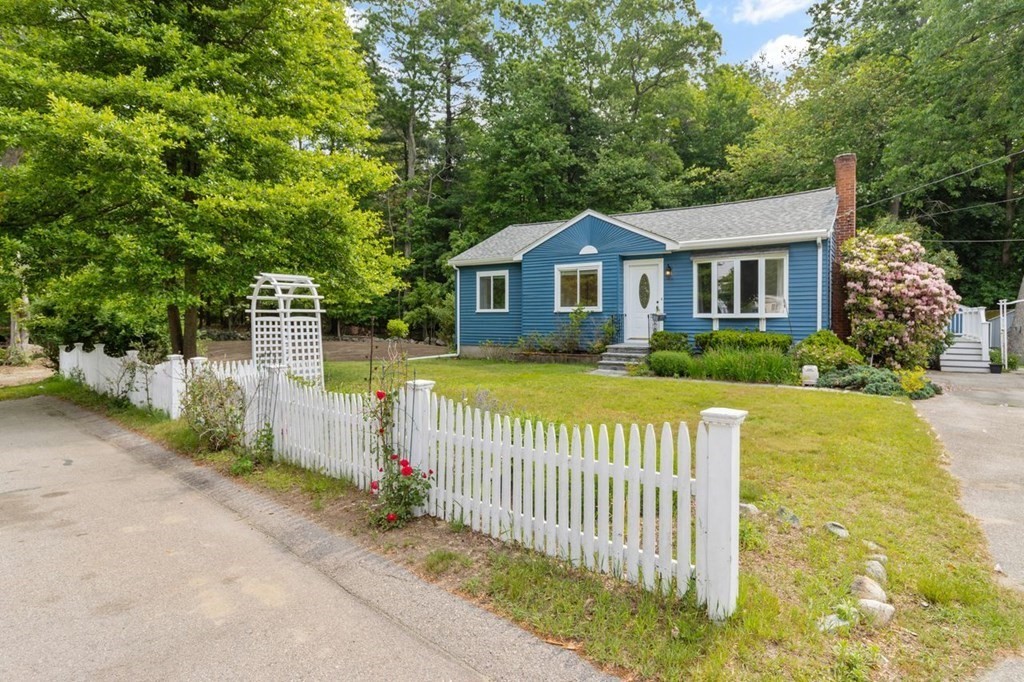 a front view of a house with a garden and yard