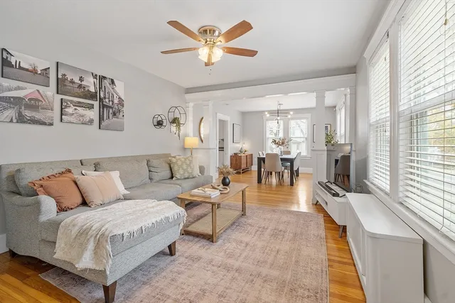 a living room with furniture fireplace and a large window