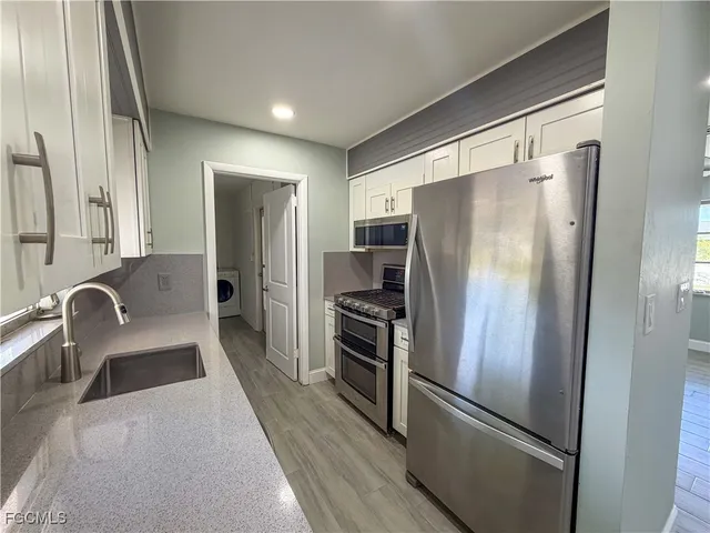 a kitchen with stainless steel appliances granite countertop a refrigerator and a sink