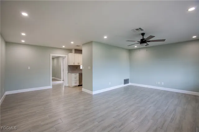 a view of a livingroom with a ceiling fan & wooden floor