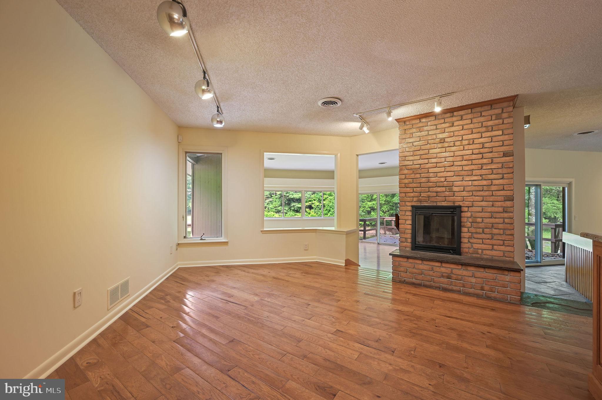 124 Meadowglen Drive Dover, DE 19901 - Photo 13 of 27 an empty room with large windows and a fireplace