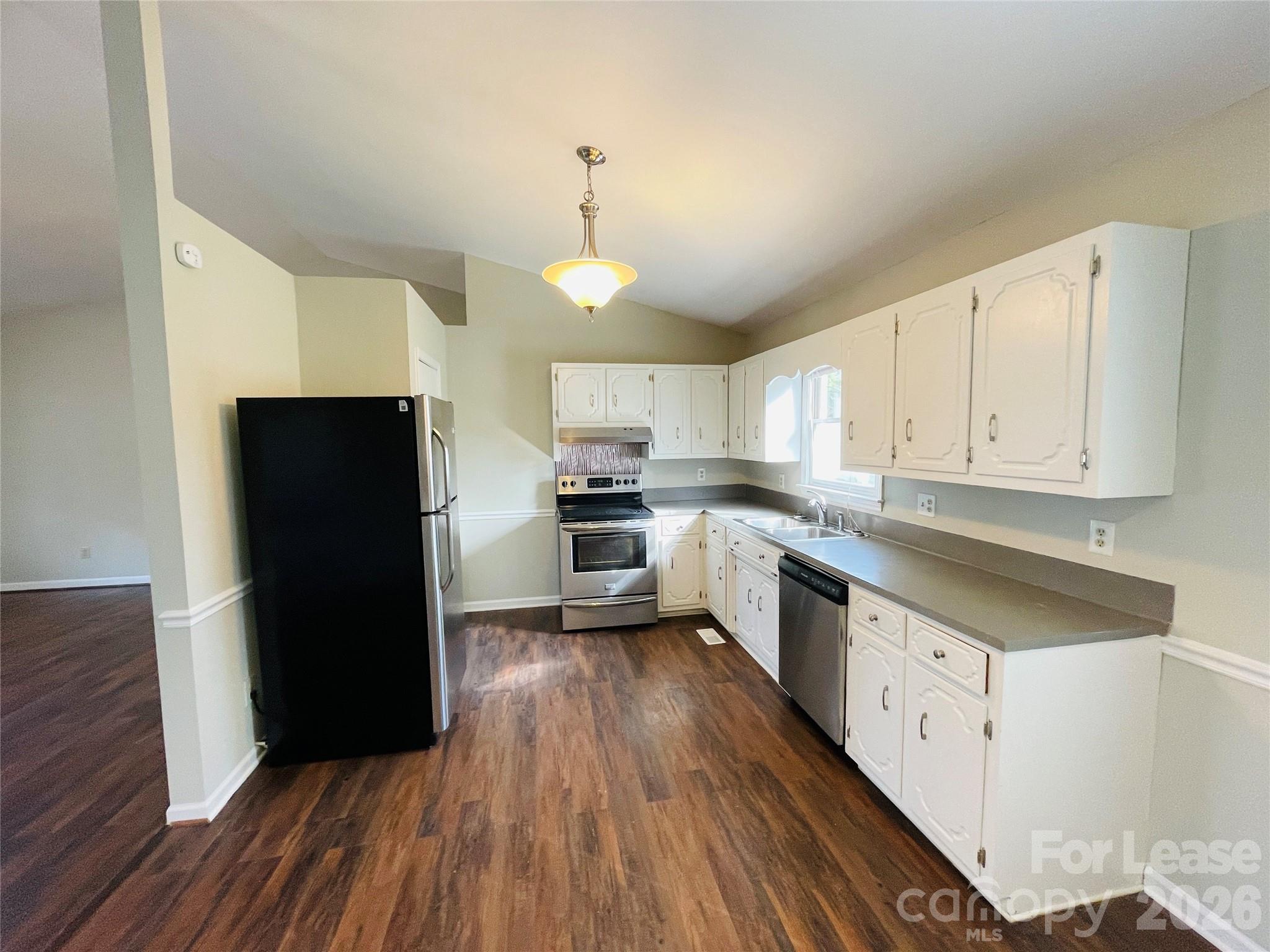 2499 Brookwood Road Lincolnton, NC 28092 - Photo 4 of 12 a kitchen with granite countertop a refrigerator a sink dishwasher a stove and white cabinets with wooden floor