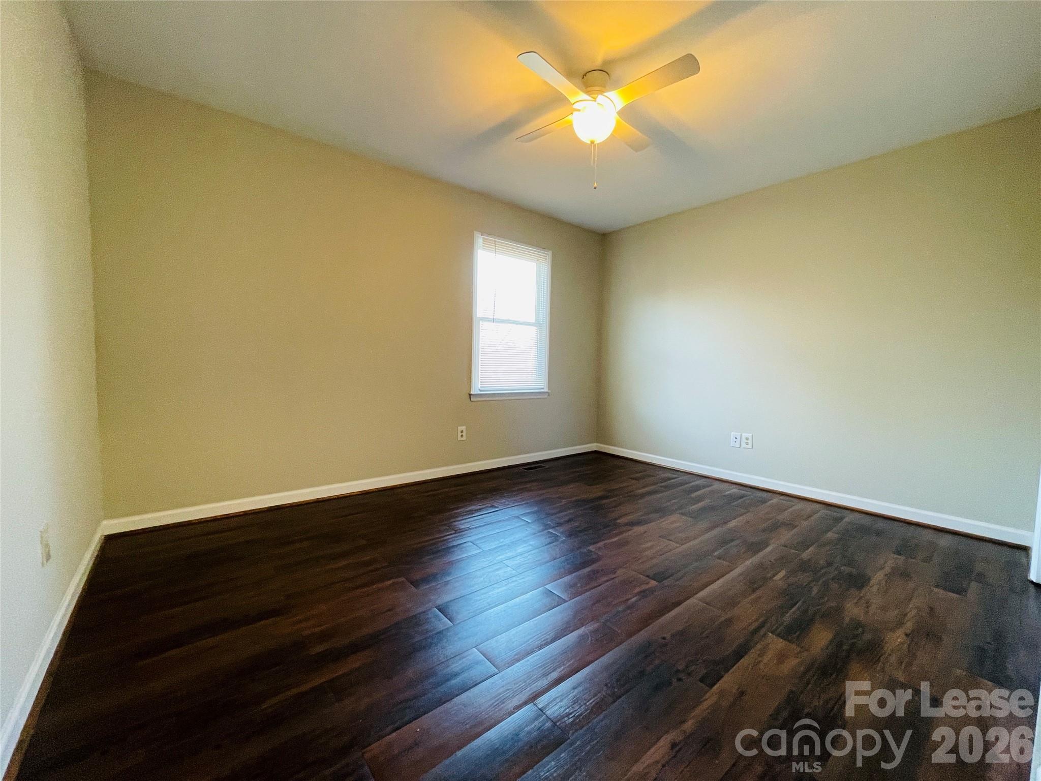 2499 Brookwood Road Lincolnton, NC 28092 - Photo 5 of 12 an empty room with wooden floor and windows