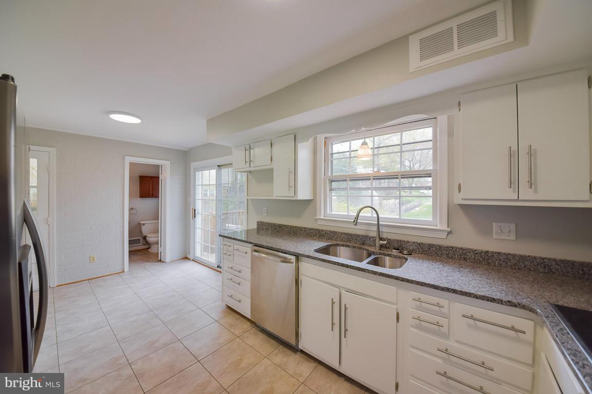 6716 Huntsman Boulevard Springfield, VA 22152 - Photo 2 of 30 a kitchen with stainless steel appliances granite countertop a sink and a white cabinets