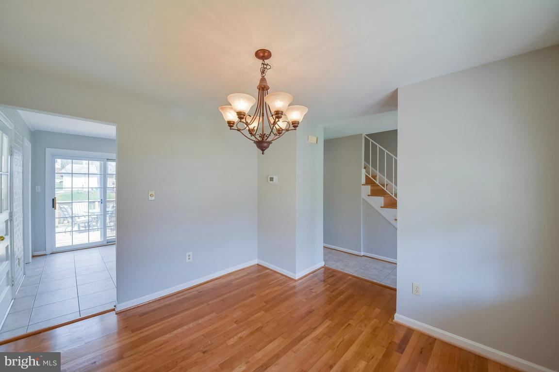 6716 Huntsman Boulevard Springfield, VA 22152 - Photo 11 of 30 a view of a bedroom with wooden floor and chandelier