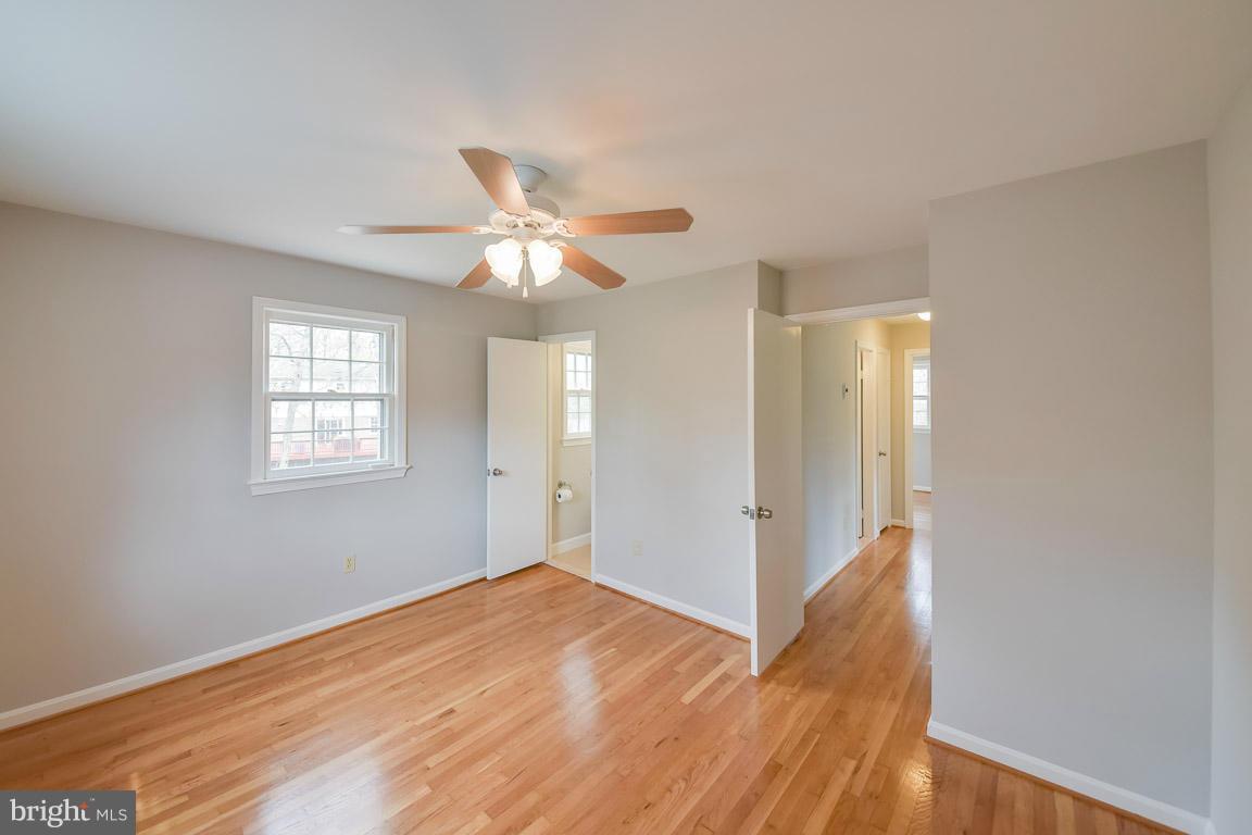 6716 Huntsman Boulevard Springfield, VA 22152 - Photo 13 of 30 a view of a room with wooden floor and a ceiling fan