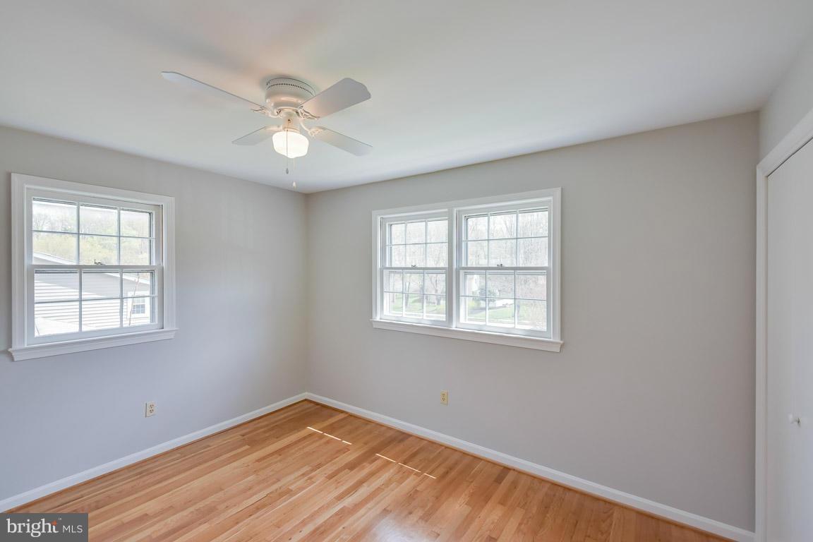 6716 Huntsman Boulevard Springfield, VA 22152 - Photo 17 of 30 a view of an empty room with wooden floor and a window