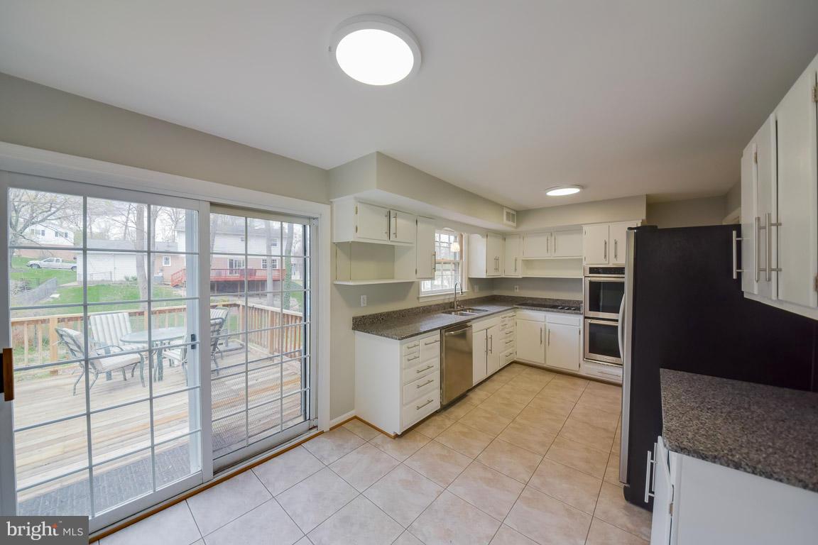6716 Huntsman Boulevard Springfield, VA 22152 - Photo 4 of 30 a kitchen with granite countertop a refrigerator and a sink