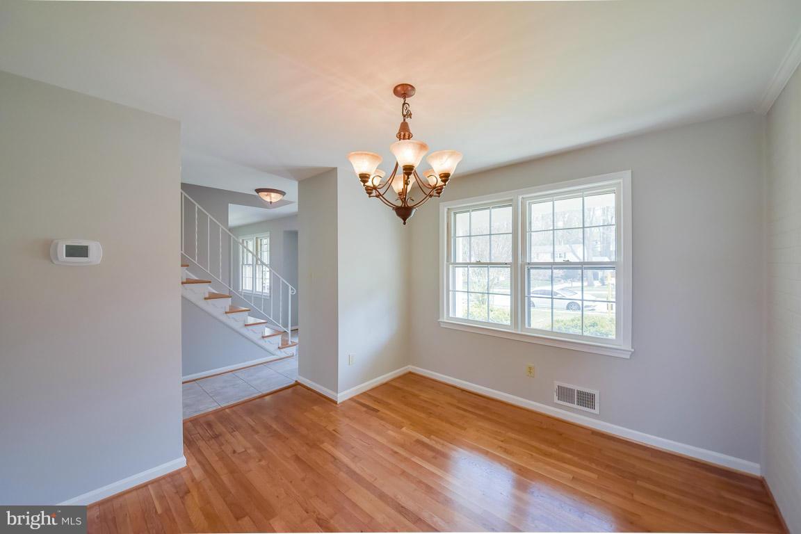 6716 Huntsman Boulevard Springfield, VA 22152 - Photo 10 of 30 a bedroom with chandelier and window