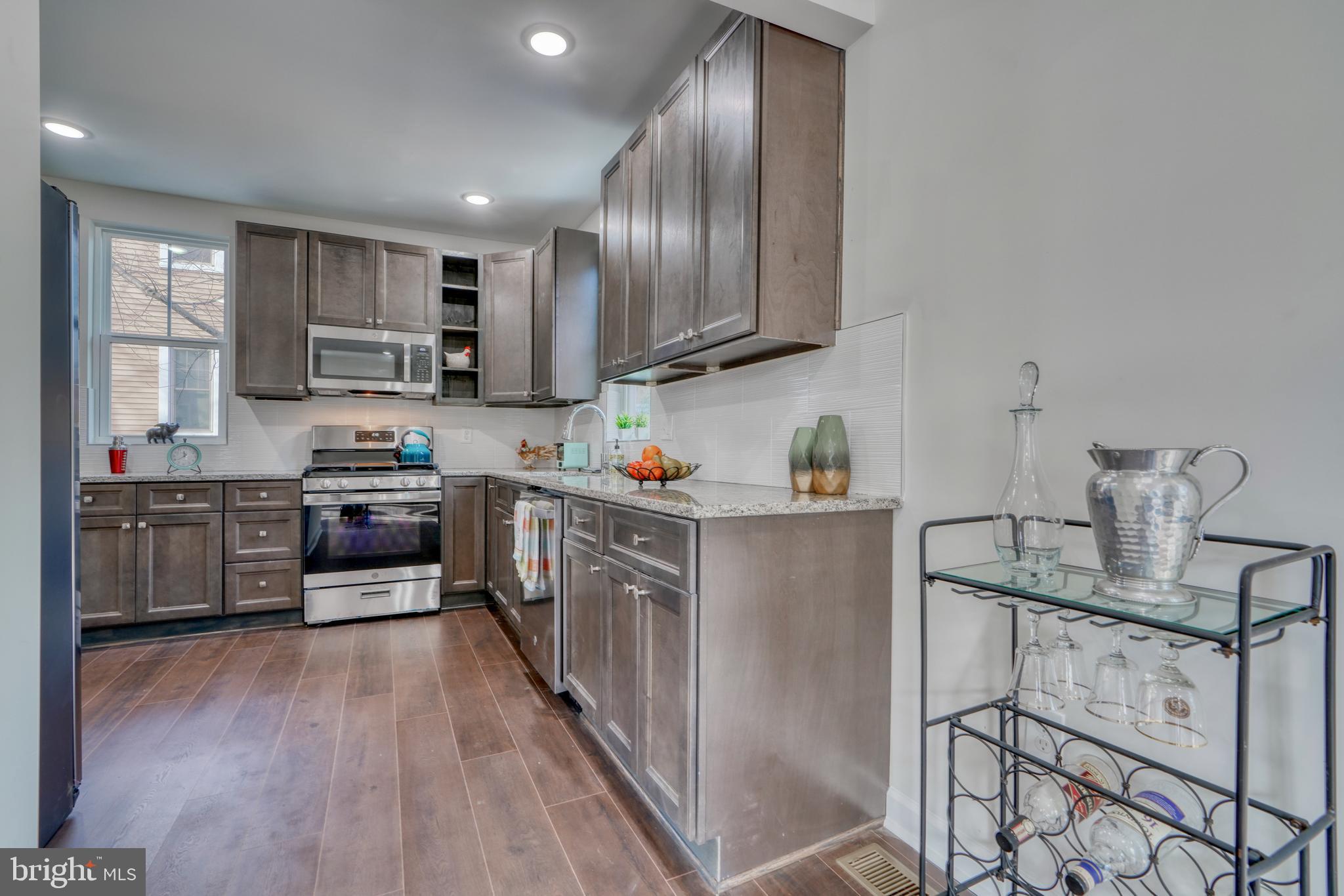 231 Mallow Hill Road Baltimore, MD 21229 - Photo 17 of 48 a kitchen with stainless steel appliances granite countertop a refrigerator and a stove top oven