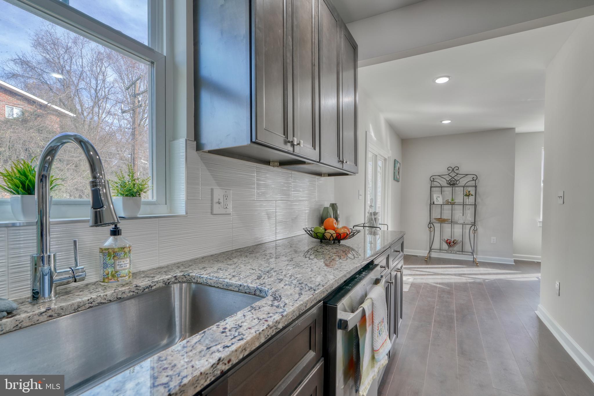 231 Mallow Hill Road Baltimore, MD 21229 - Photo 21 of 48 a kitchen with granite countertop a sink a stove and cabinets