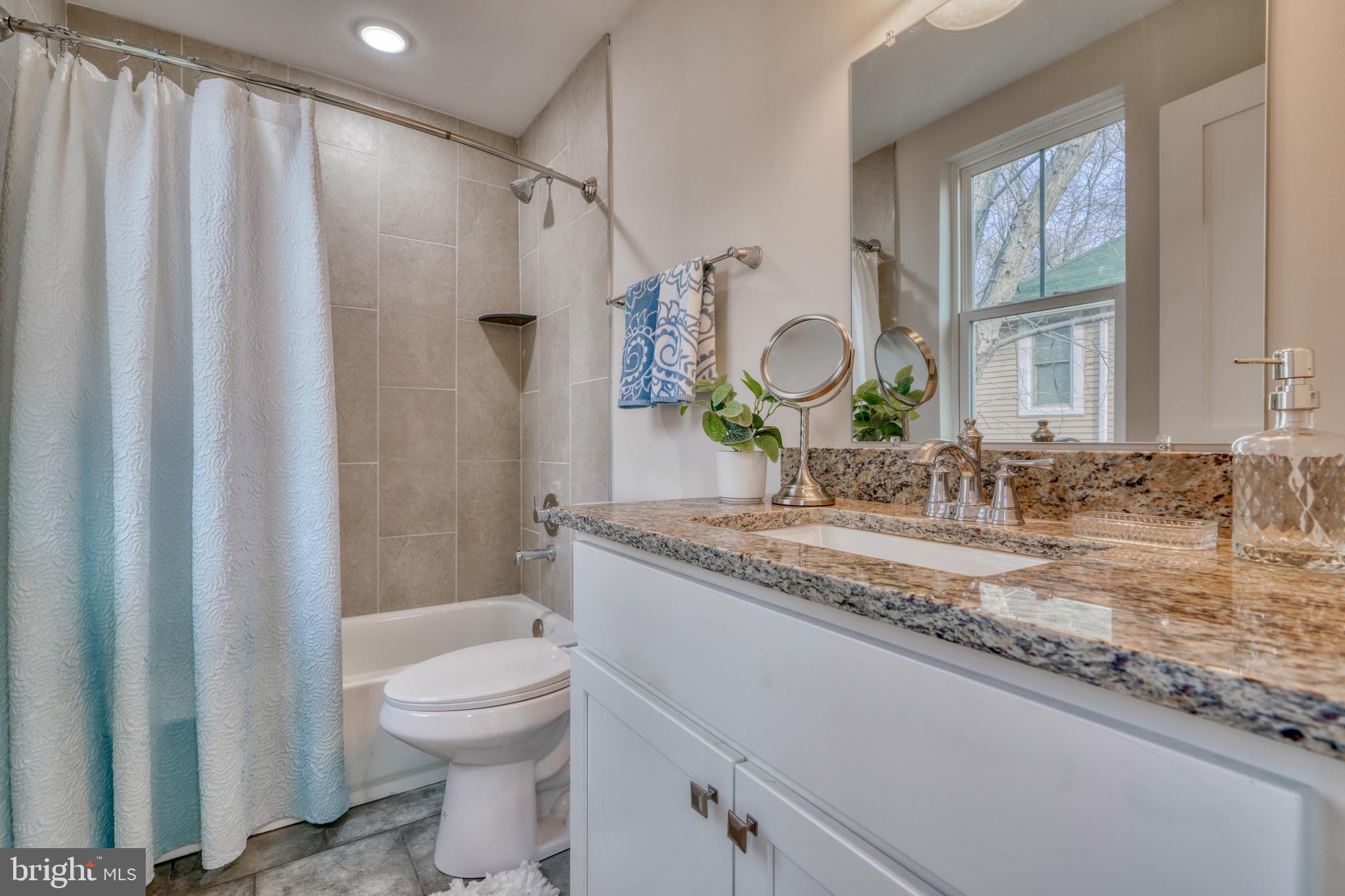 231 Mallow Hill Road Baltimore, MD 21229 - Photo 26 of 48 a bathroom with a granite countertop sink mirror vanity and toilet