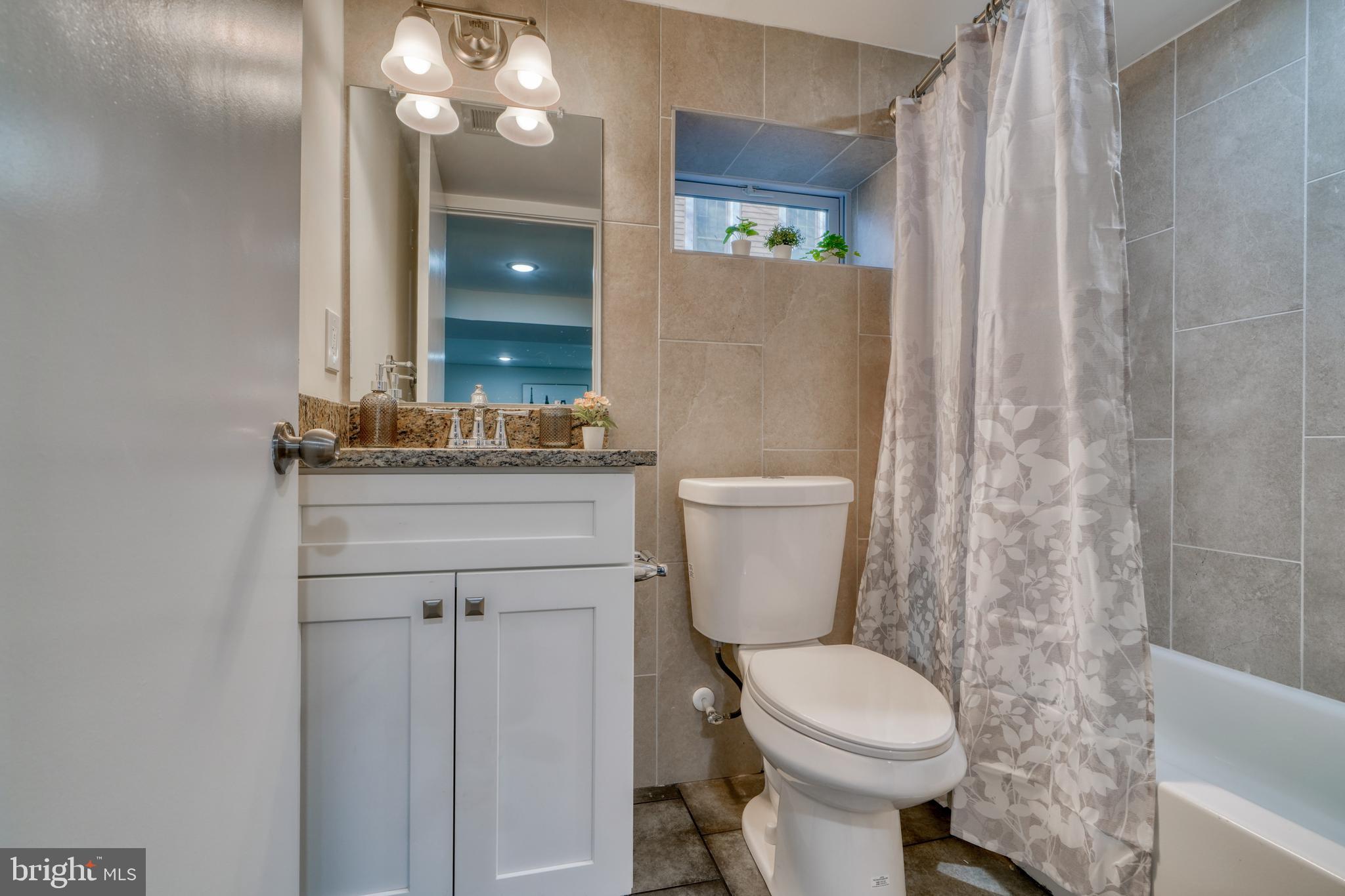 231 Mallow Hill Road Baltimore, MD 21229 - Photo 43 of 48 a bathroom with a toilet sink and mirror