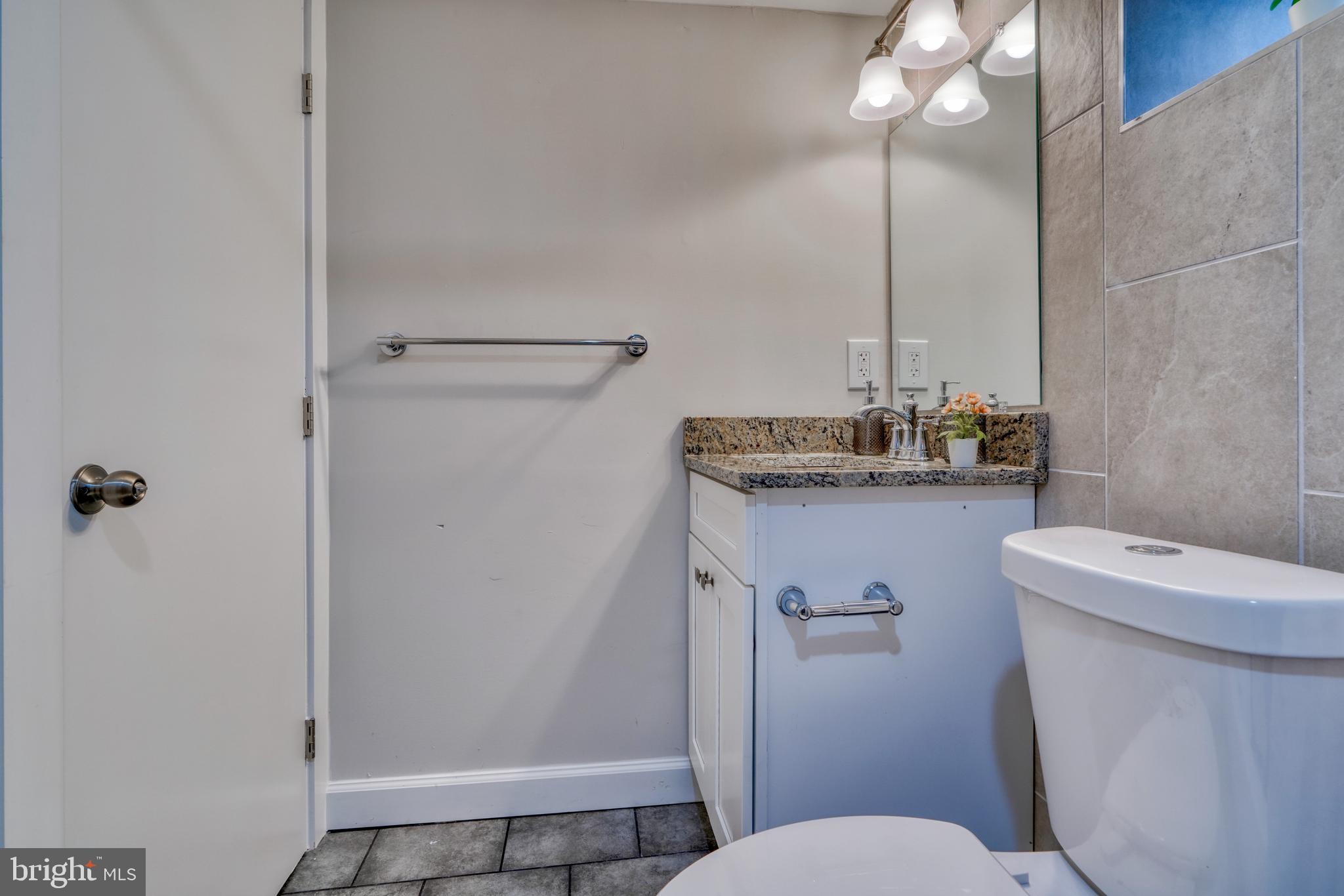 231 Mallow Hill Road Baltimore, MD 21229 - Photo 45 of 48 a bathroom with a sink a toilet a mirror and shower