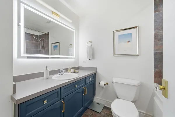 a bathroom with a toilet sink and mirror