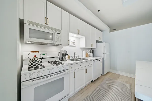 a kitchen with white cabinets and appliances