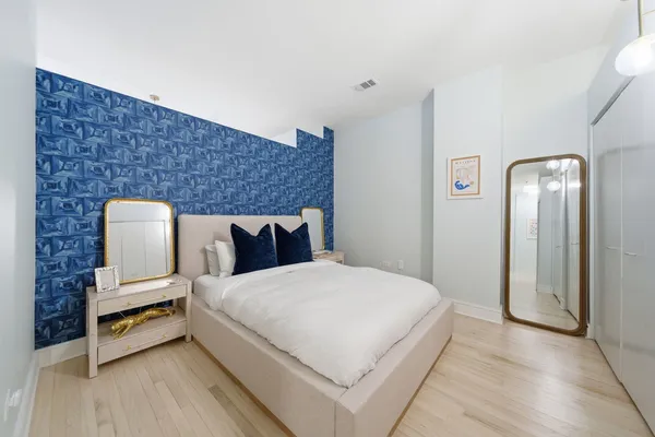 a spacious bedroom with a bed and a night stand