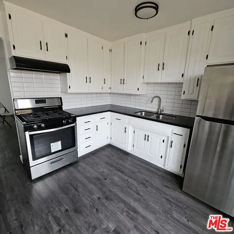 a kitchen with granite countertop white cabinets and white appliances
