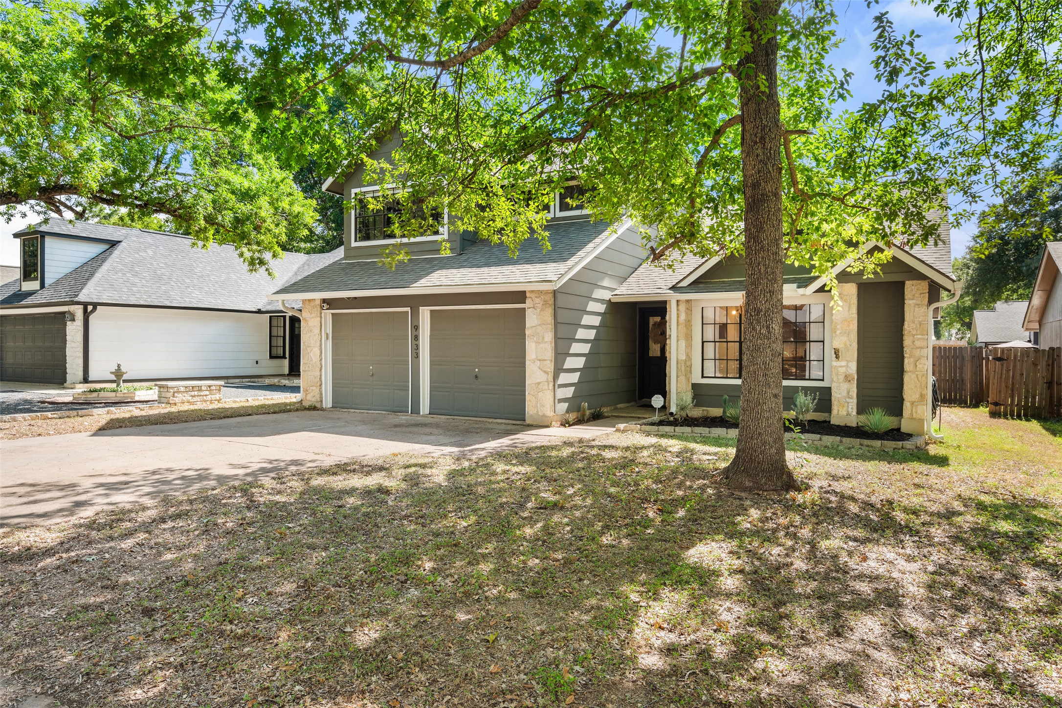9833 Briar Ridge Drive Austin, TX 78748 - Photo 2 of 29 View of front of house with a shingled roof, a garage, driveway, and stone siding