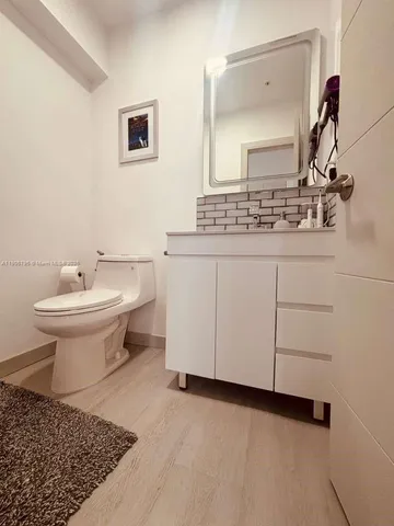 a bathroom with a sink toilet and mirror