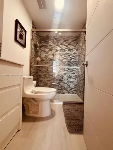 a bathroom with a toilet and a shower
