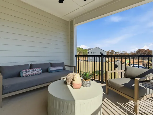 a balcony with furniture and a potted plant
