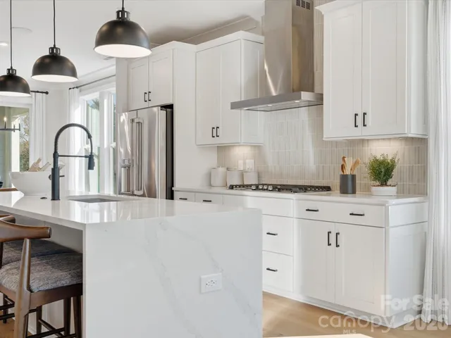 a kitchen with stainless steel appliances a stove refrigerator and cabinets