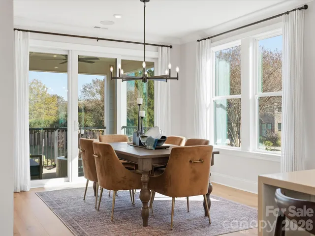 a dining room with furniture a chandelier and wooden floor
