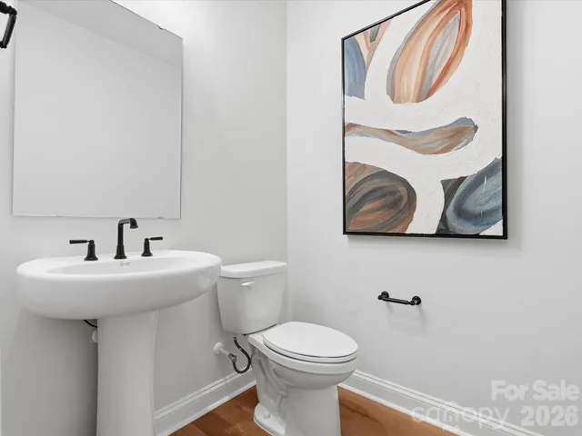 a white toilet sitting next to a white sink and a mirror