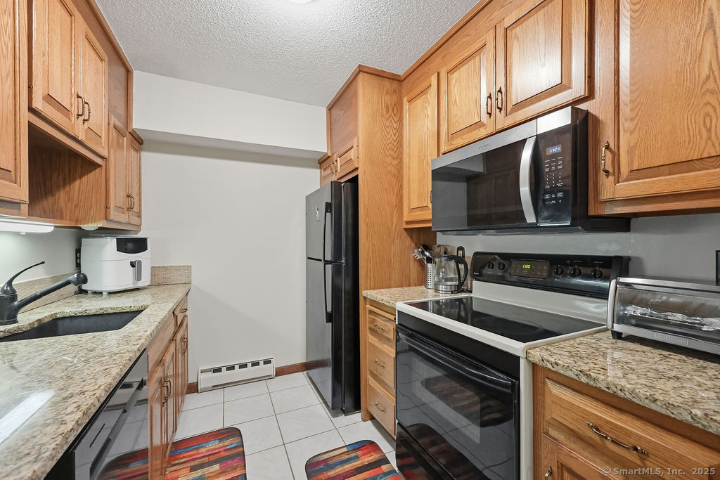 25 Washington Street, Unit 20 Bristol, CT 06010 - Photo 11 of 29 a kitchen with stainless steel appliances granite countertop a refrigerator stove and sink