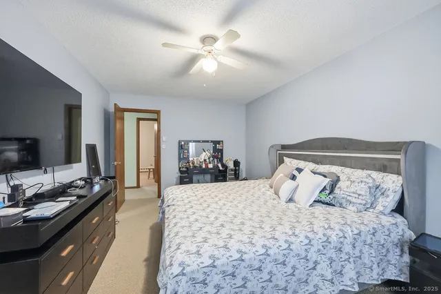 a bedroom with a bed and a flat tv screen on dresser