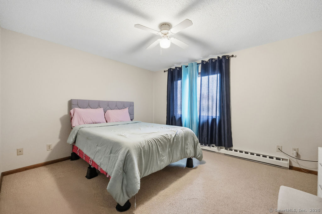 25 Washington Street, Unit 20 Bristol, CT 06010 - Photo 21 of 29 a spacious bedroom with a bed and a chandelier
