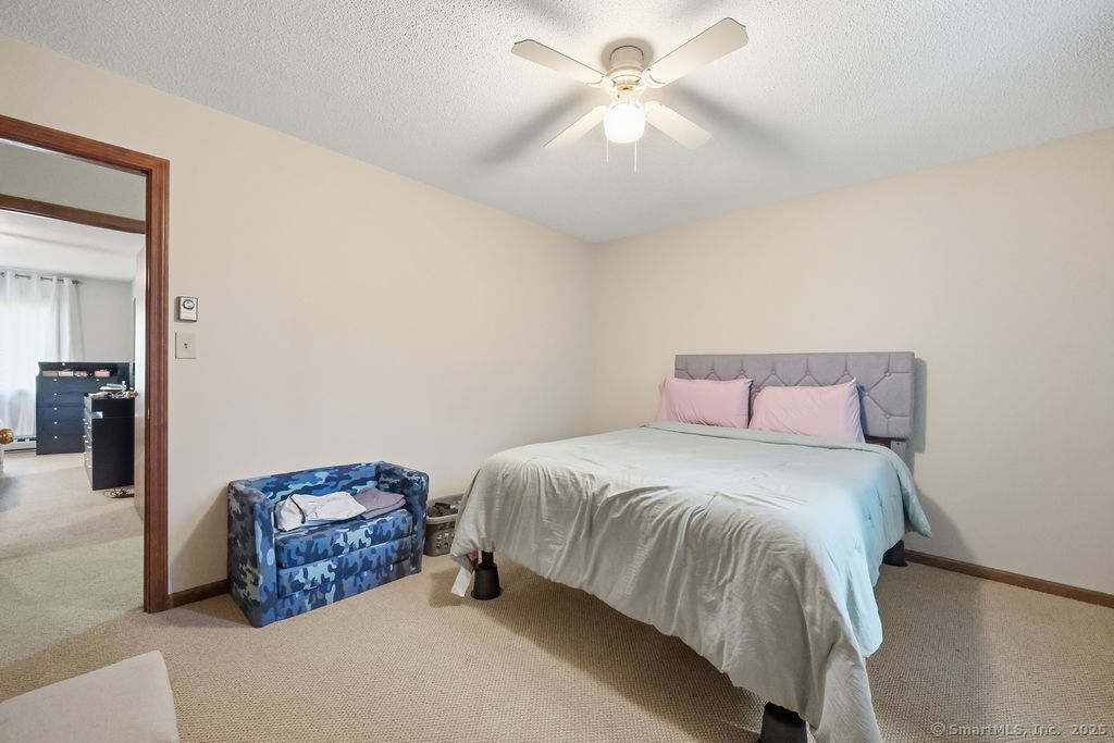 25 Washington Street, Unit 20 Bristol, CT 06010 - Photo 22 of 29 a spacious bedroom with a bed a ceiling fan and a dresser