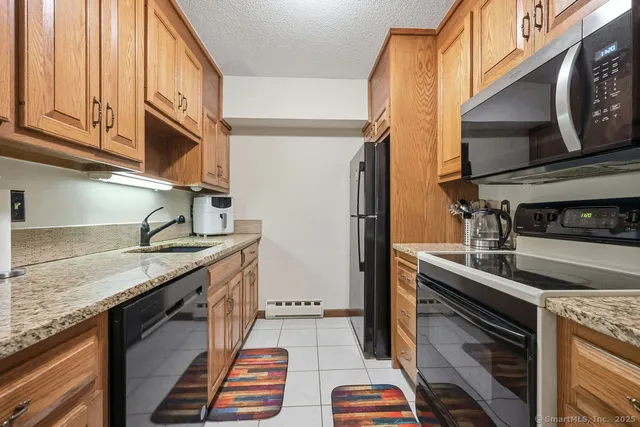 a kitchen with granite countertop stainless steel appliances a counter top space and cabinets