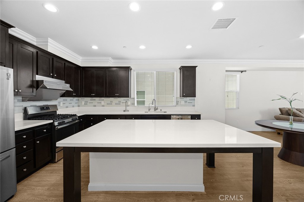 3632 Jackson Baldwin Park, CA 91706 - Photo 15 of 24 a kitchen with kitchen island a sink dishwasher a stove and a refrigerator with wooden floor