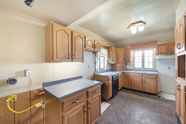 a view of a hallway with wooden floor and cabinet
