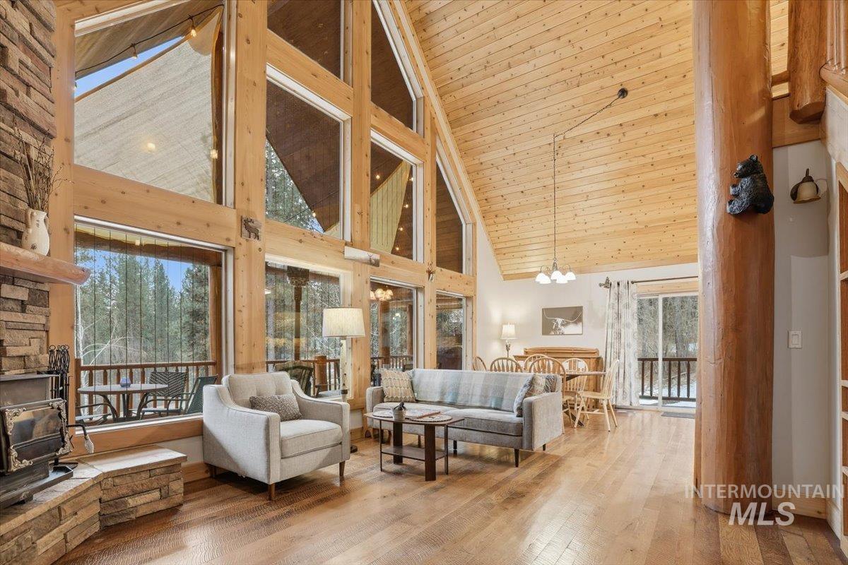 20 Valley High Road Garden Valley, ID 83622 - Photo 2 of 46 Living room with a wood stove, high vaulted ceiling, wood-type flooring, wood ceiling, and a chandelier