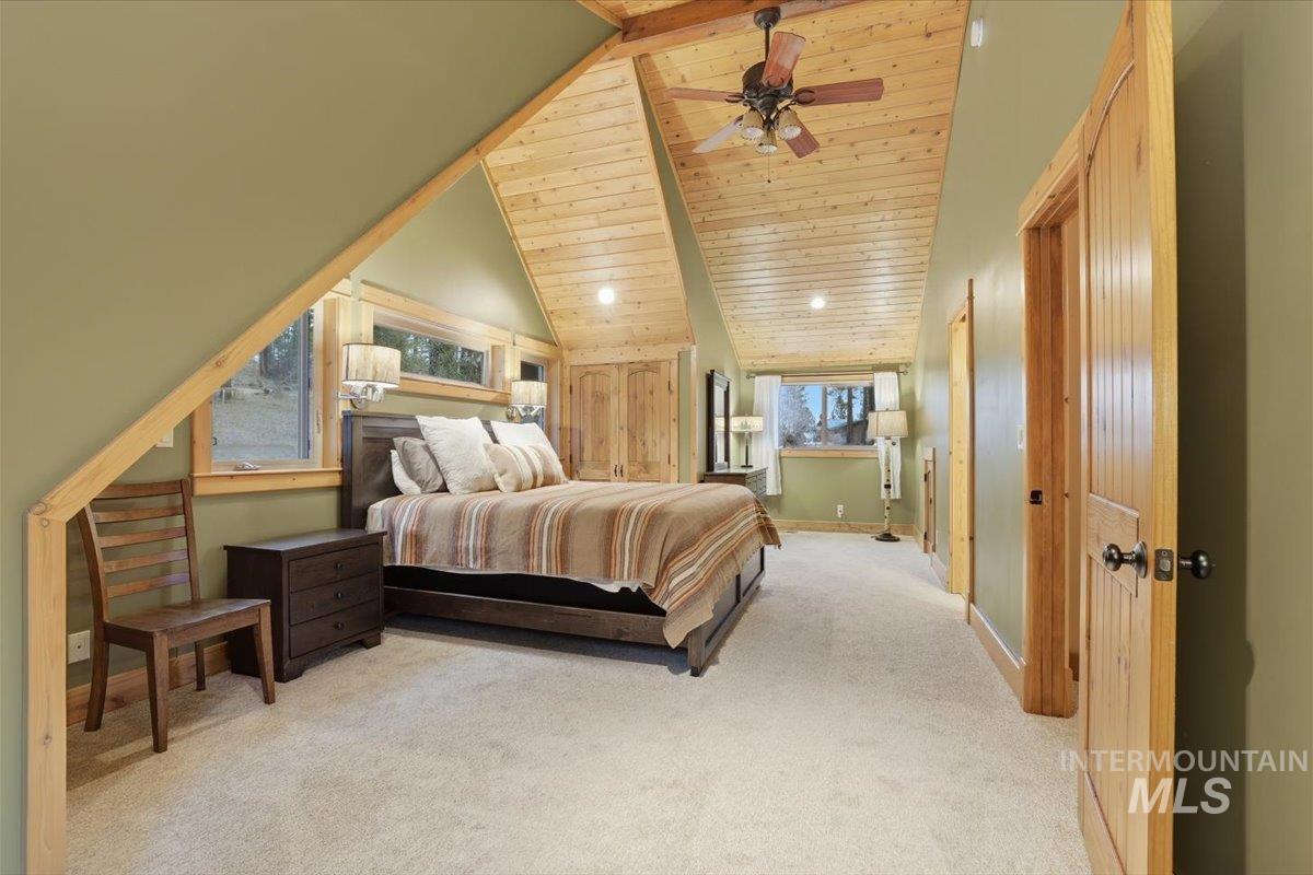 20 Valley High Road Garden Valley, ID 83622 - Photo 23 of 46 Bedroom featuring high vaulted ceiling, a wooden ceiling with exposed beams, light carpet, and ceiling fan