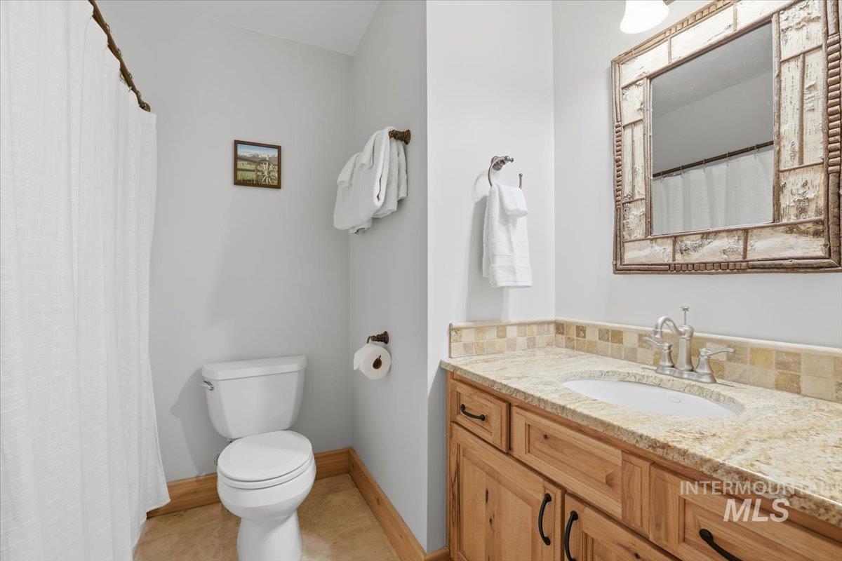 20 Valley High Road Garden Valley, ID 83622 - Photo 25 of 46 Full bath with a shower with shower curtain, vanity, and light tile patterned flooring